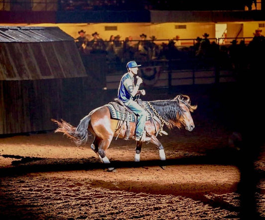 Sponsored rider Nate Eicher competing in a western rodeo event, showcasing horsemanship and cowboy skills under arena lights