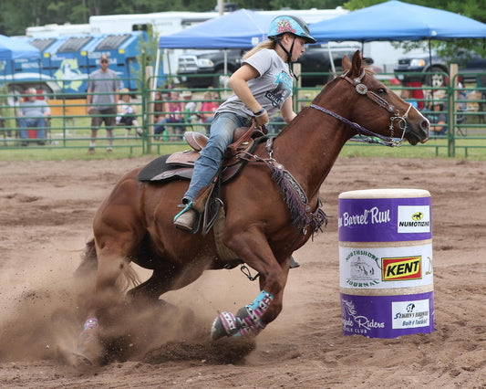 Renegade Riders Saddle Club barrel racing event, featuring a young rider guiding a horse around a barrel with speed and precision in a competitive arena